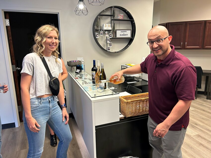 Visitors to a chiropractic office in Parker participate in the Wine Walk in June 2023.
